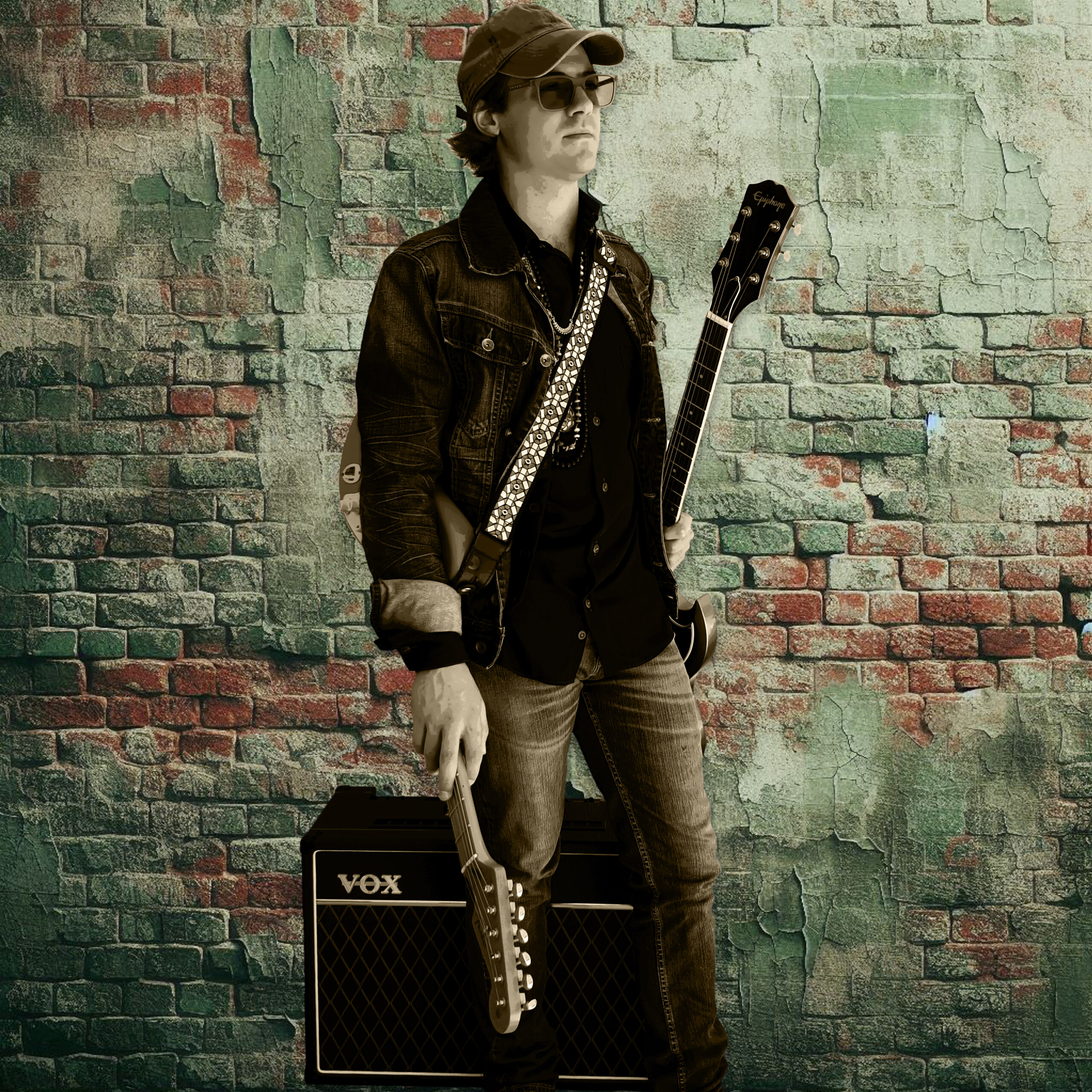 Jac Zamar with an electric guitar against a cool blue-grey mountain backdrop